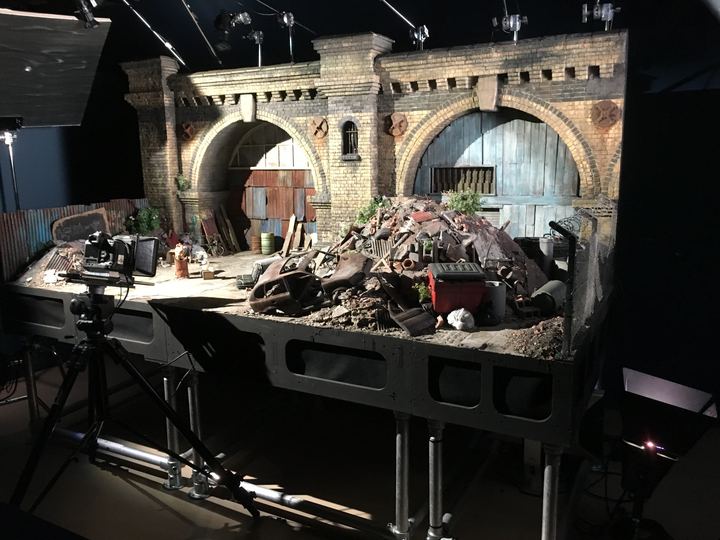 A detailed miniature stop-motion film set from an Aardman production, with a camera and lights
