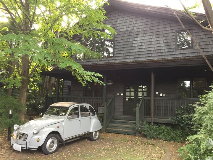 Hayao Miyazaki's small wooden personal studio building in Tokyo with a classic car parked outside