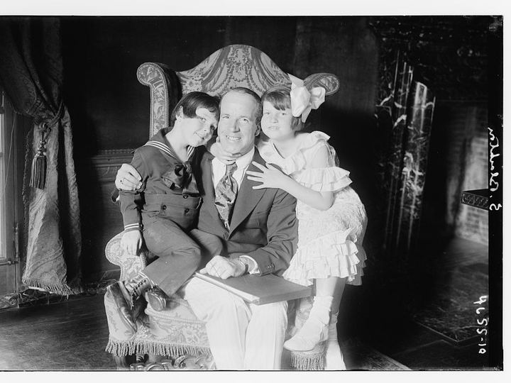 J. Stuart Blackton seated in a large chair with two of his children, around 1910s