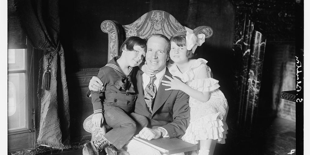 J. Stuart Blackton seated in a large chair with two of his children, around 1910s