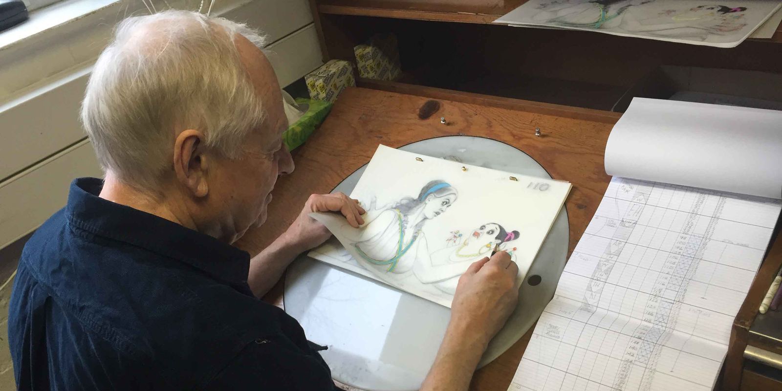 Animator Richard Williams drawing at a desk at Aardman Animations in 2015